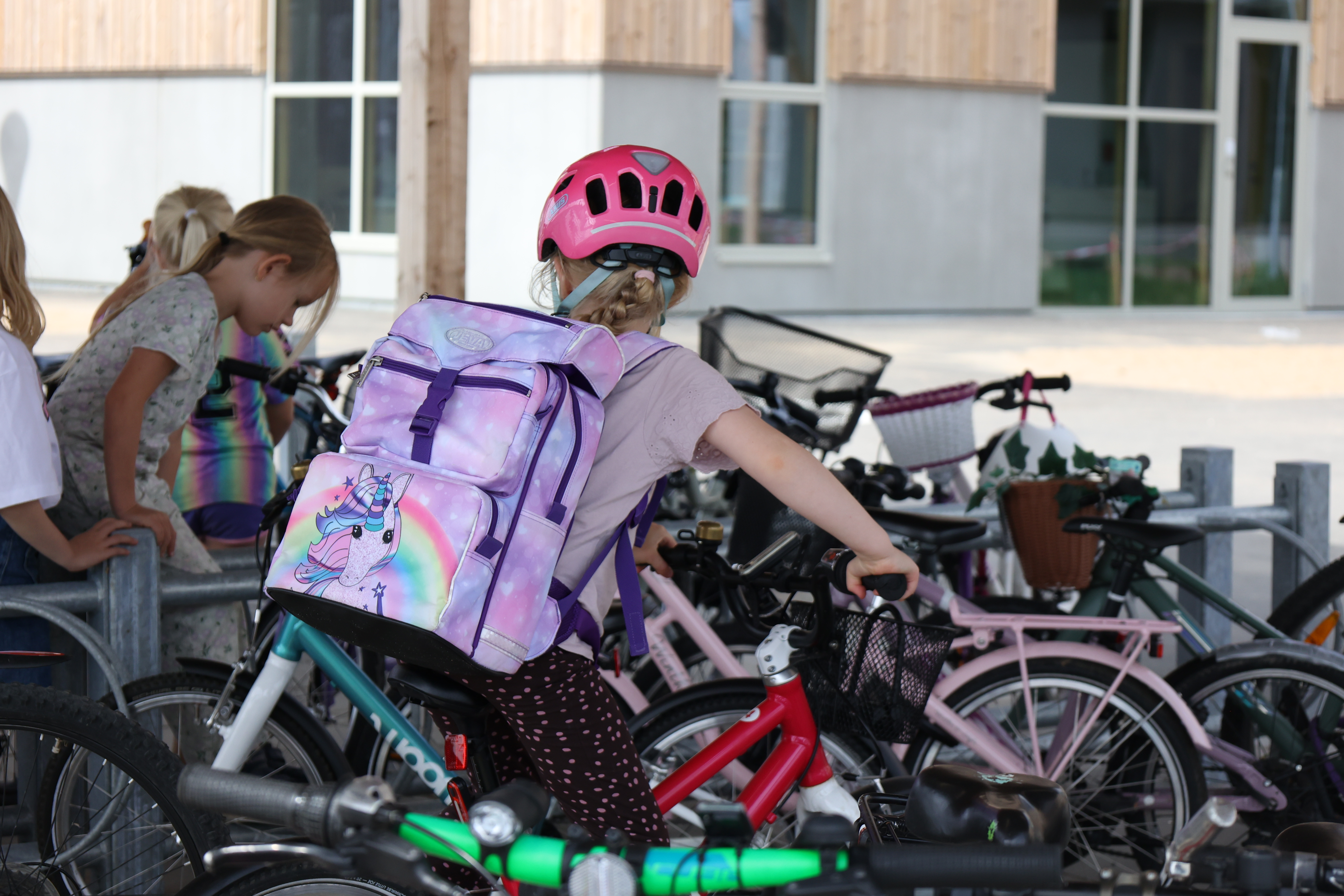 En pige ved cykelparkeringen på Ravnbakkeskolen